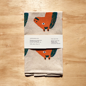 Folded towel with fox design on a wooden surface