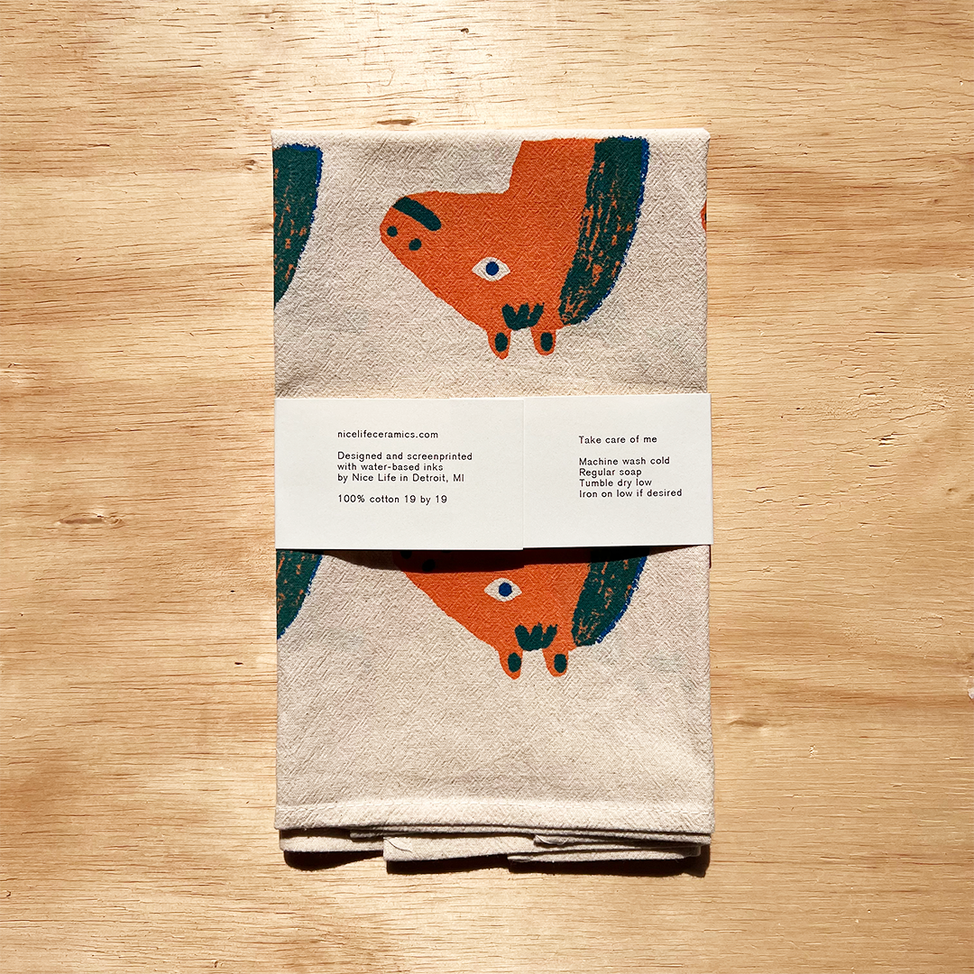 Folded towel with fox design on a wooden surface