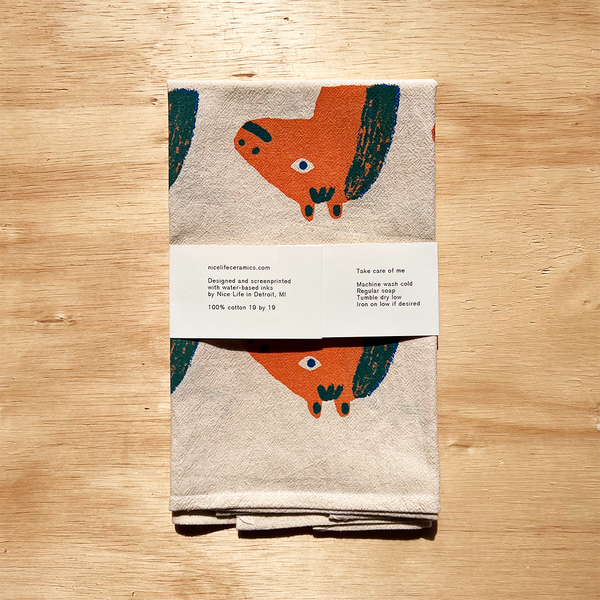 Folded towel with fox design on a wooden surface