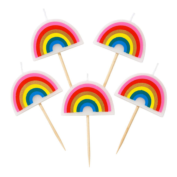 Five rainbow-shaped candles on sticks against a white background