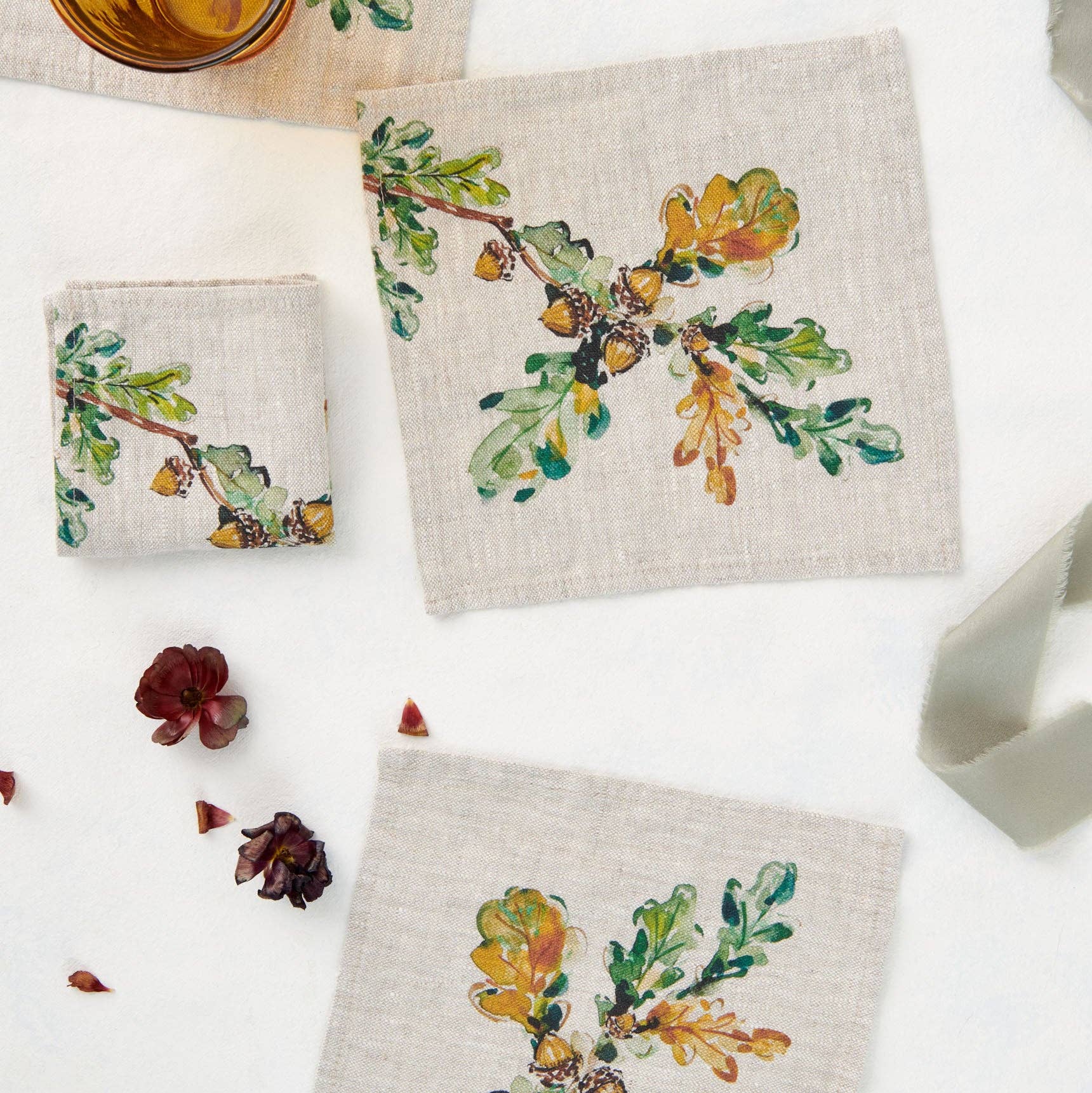 Set of three linen coasters with autumn-themed designs on a white surface.