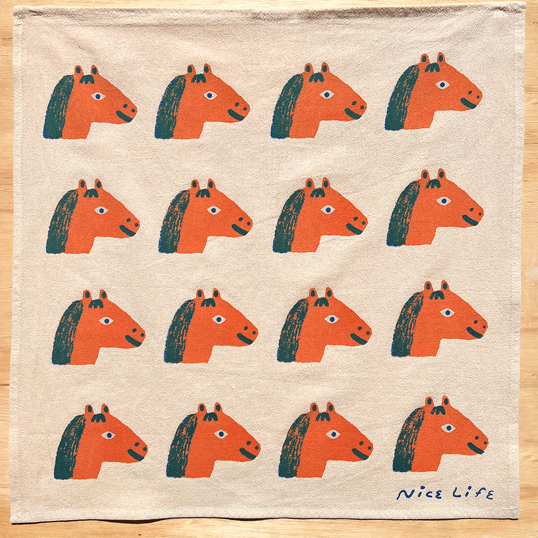Fabric with orange horse heads pattern on a beige background, branded 'Nice Life'.