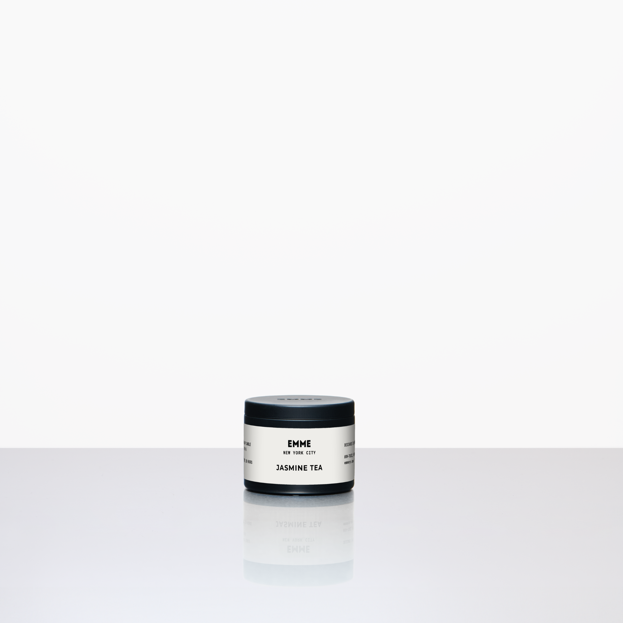 Small container of a jasmine tea candle on a white background