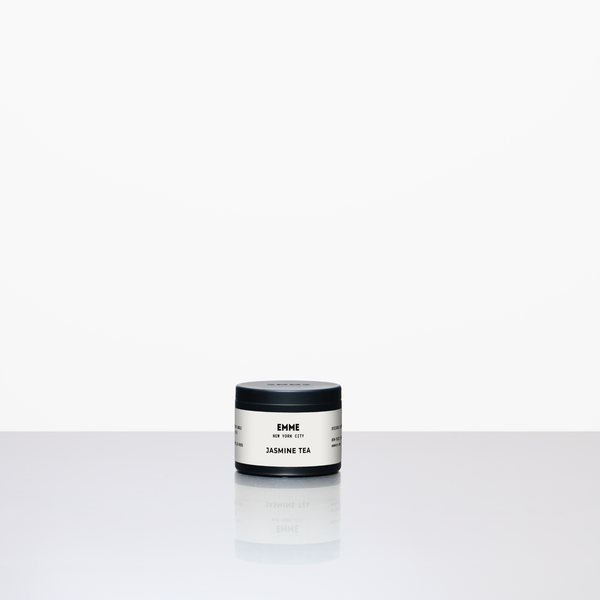 Small container of a jasmine tea candle on a white background