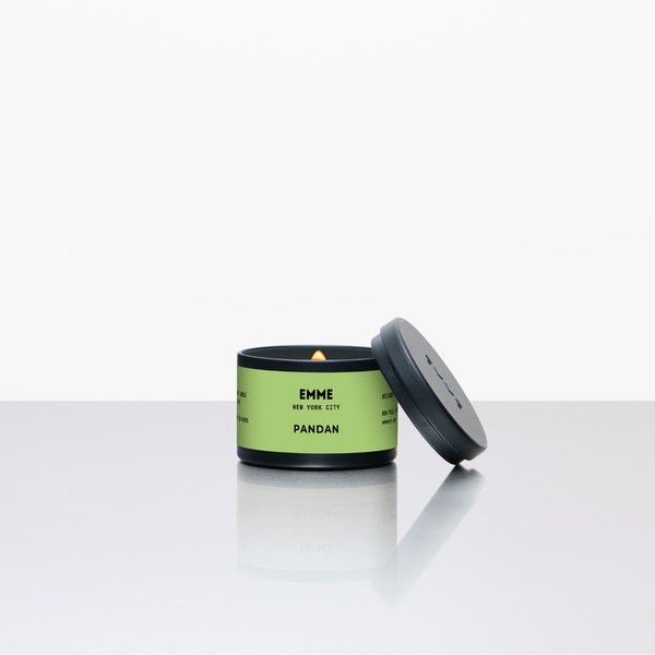 Green candle with a black lid on a white background
