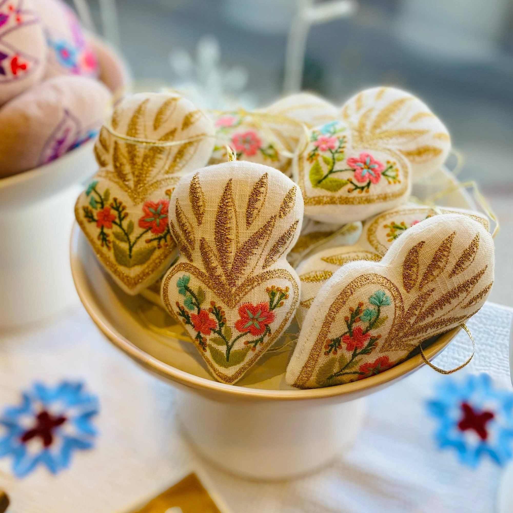 Decorative heart-shaped ornaments with floral designs on a white plate.