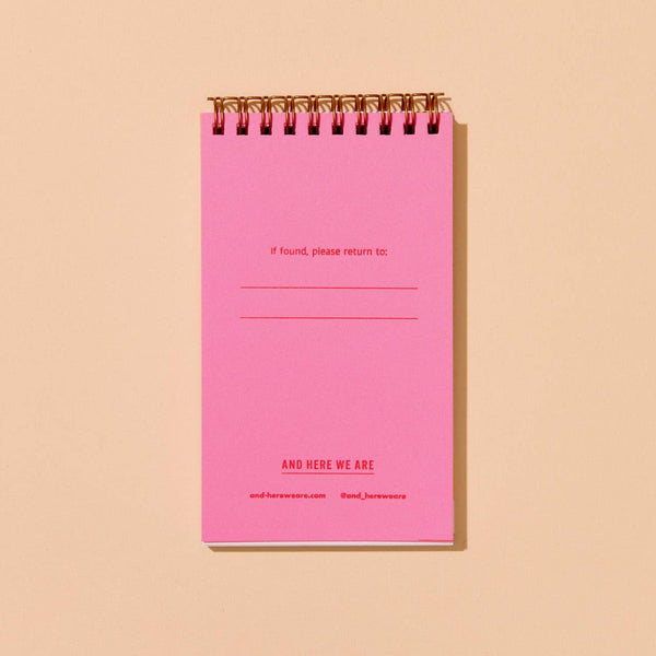 Pink page within spiral-bound notebook that says "if found, please return to:" on a beige background
