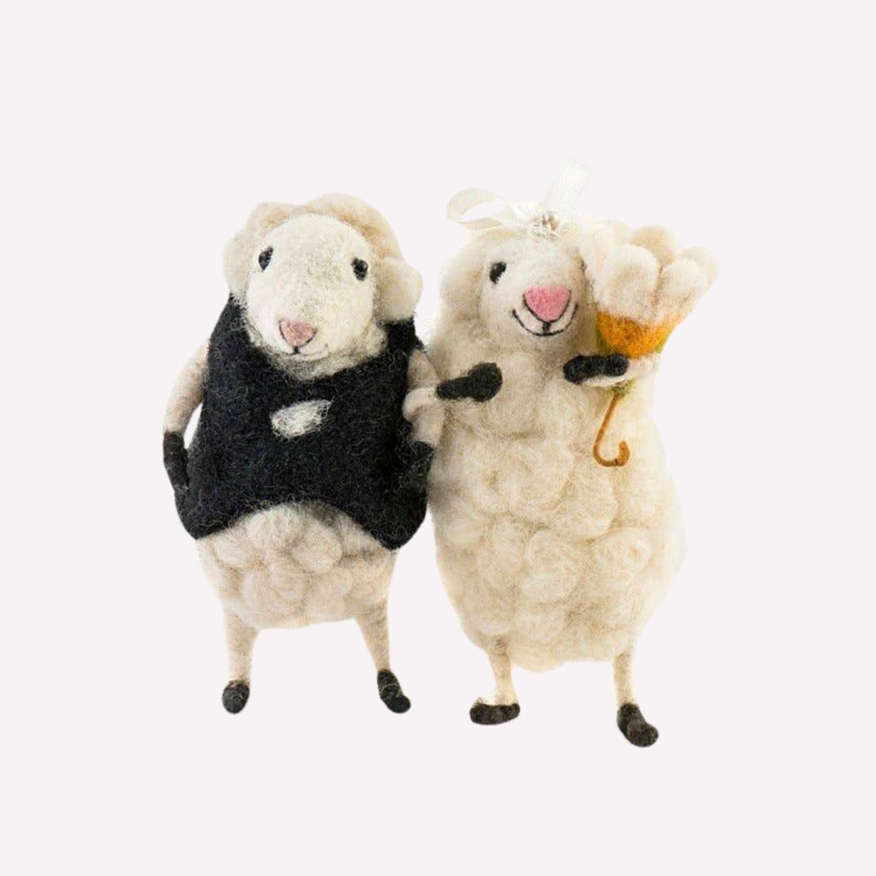 Two bride and groom sheep figurines on a white background