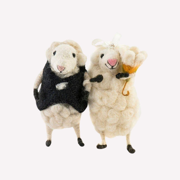 Two bride and groom sheep figurines on a white background