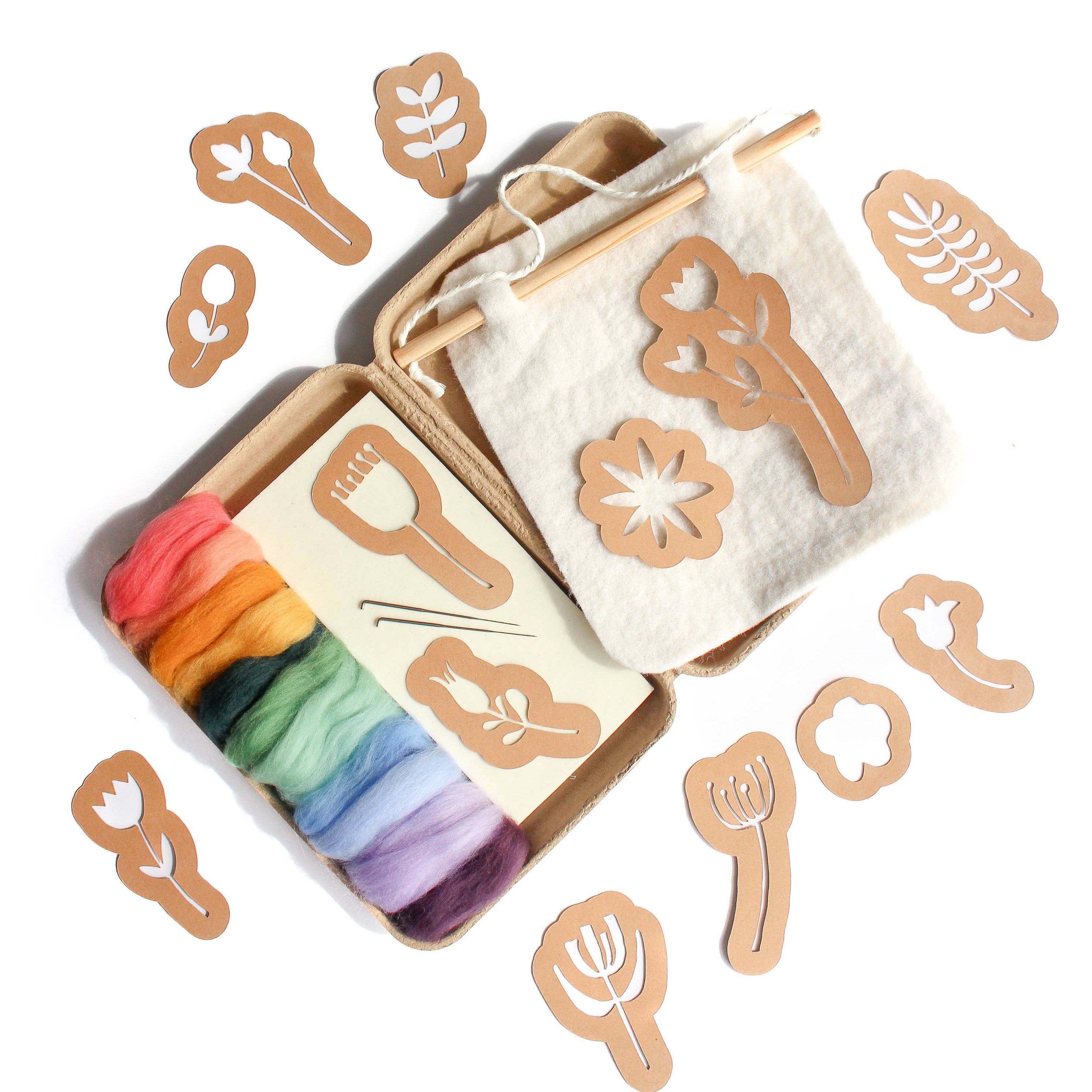 Set of wooden stencils with a rainbow-colored wool on a white background