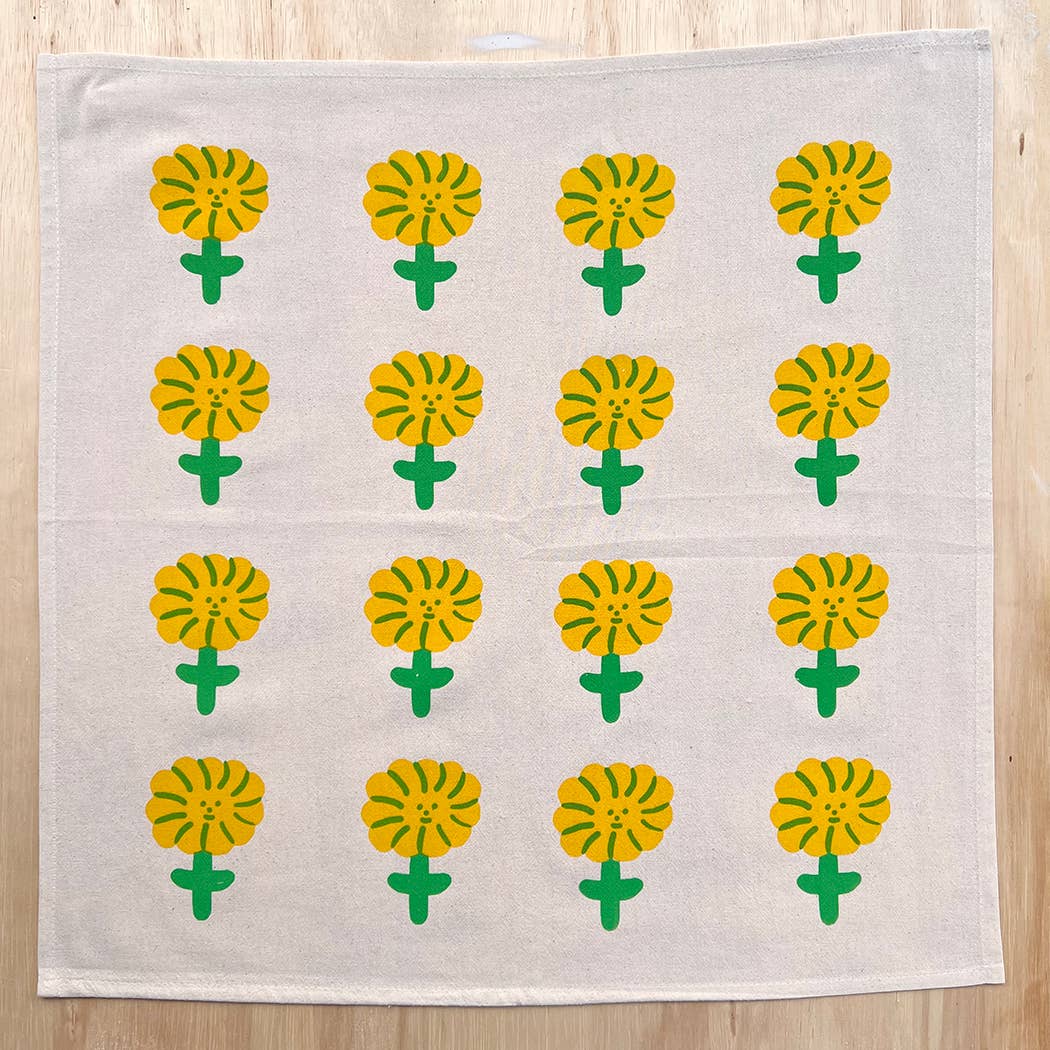 White towel with yellow flower patterns on a wooden surface