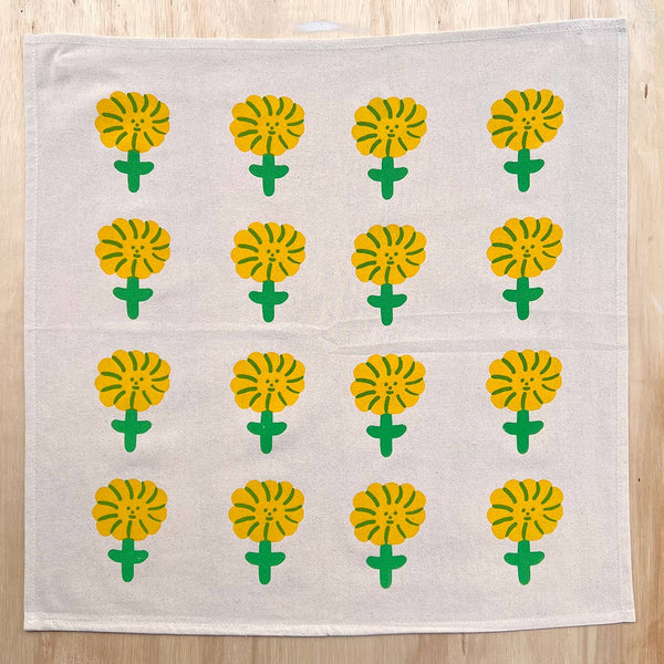 White towel with yellow flower patterns on a wooden surface