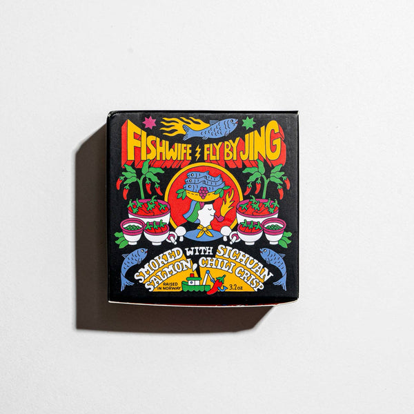 A packaged product labeled 'FISHWIFE X FLY BY JING' featuring Sichuan Smoked Salmon with Fly By Jing Sichuan Chili Crisp, with colorful and decorative graphics including chili peppers.