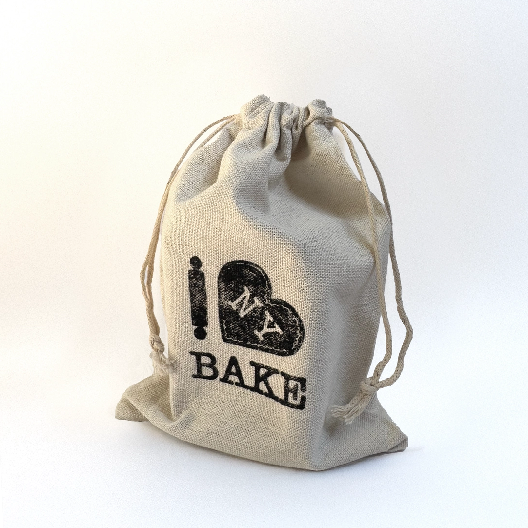 Beige drawstring bag with 'I ❤️ NY BAKE' text on a white background