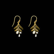 Gold leaf earrings with pearl drops on a plain background