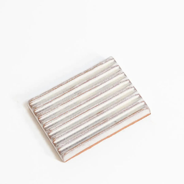 Rectangular ceramic soap dish with striped pattern on a white background