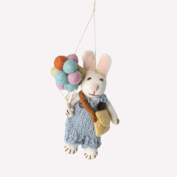 Stuffed toy rabbit with colorful balloons on a white background