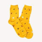 Bright yellow crew socks with a Halloween pattern featuring black bats, orange jack-o'-lanterns, white ghosts, and black spiders, laid flat on a white background.