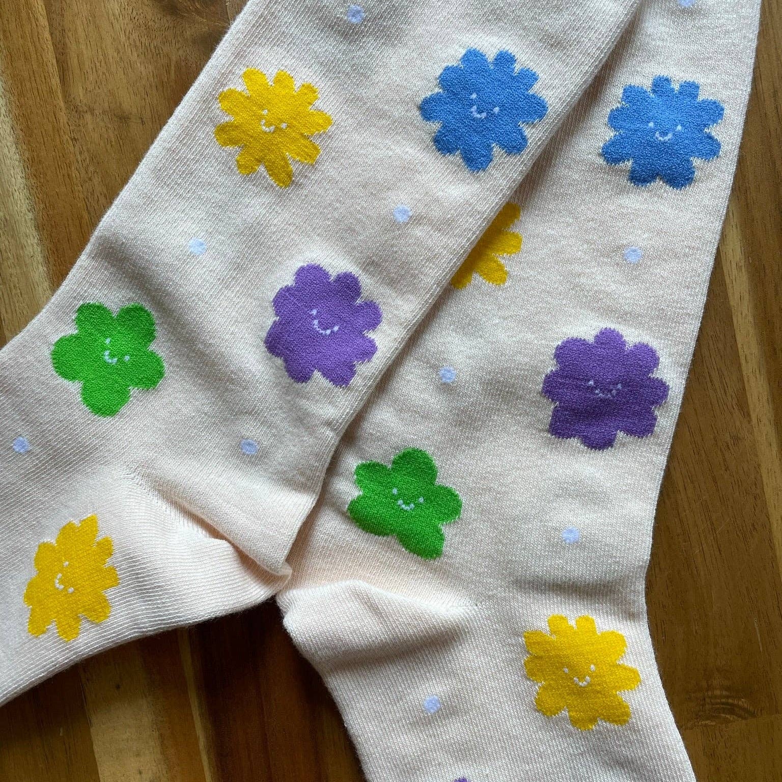 Children's tights with colorful flower patterns on a wooden floor.