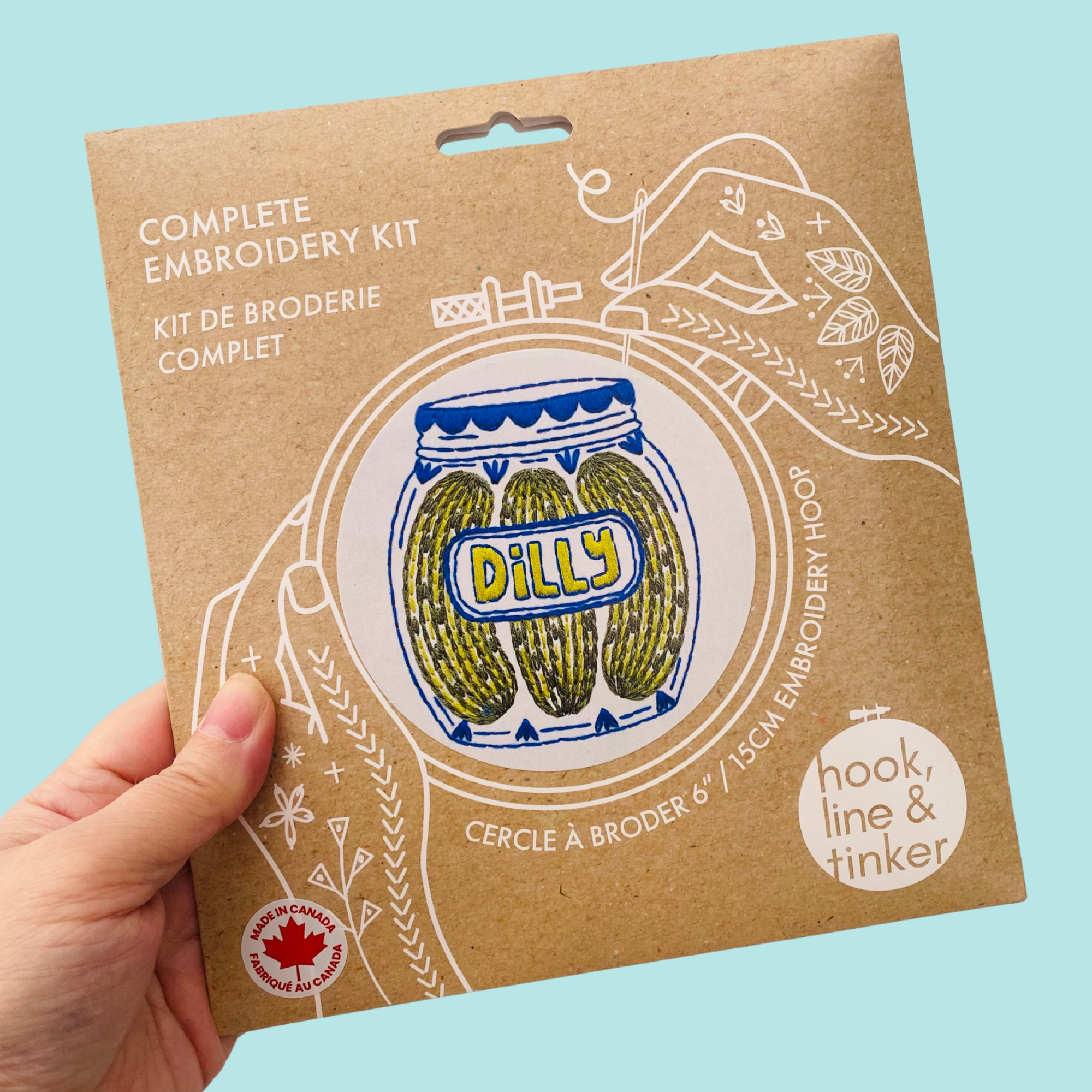 Embroidery kit packaging with 'Dilly' design on a blue background