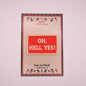 Iron on patch with 'OH, HELL YES!' text on a branded backing card.