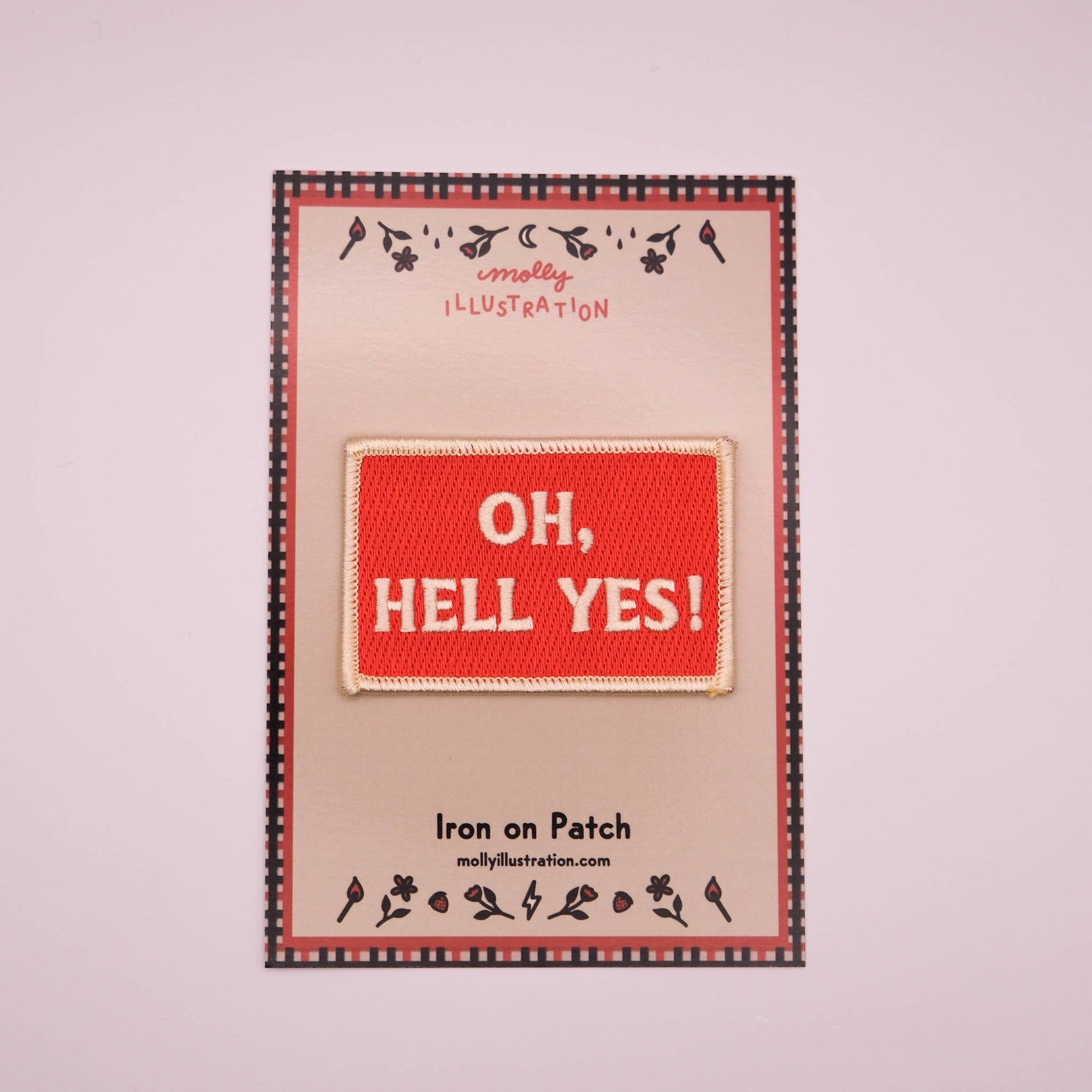 Iron on patch with 'OH, HELL YES!' text on a branded backing card.