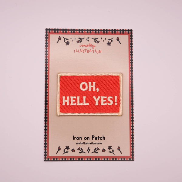 Iron on patch with 'OH, HELL YES!' text on a branded backing card.