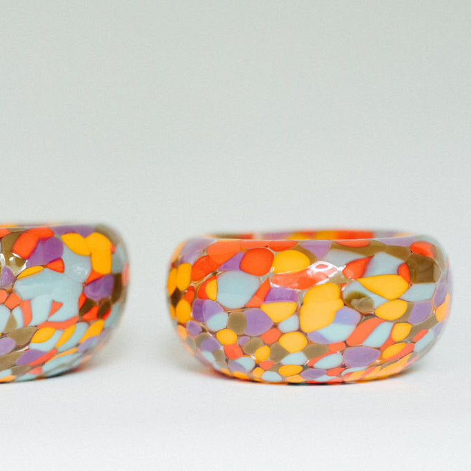 Colorful polka dot glass bowl on a wooden surface