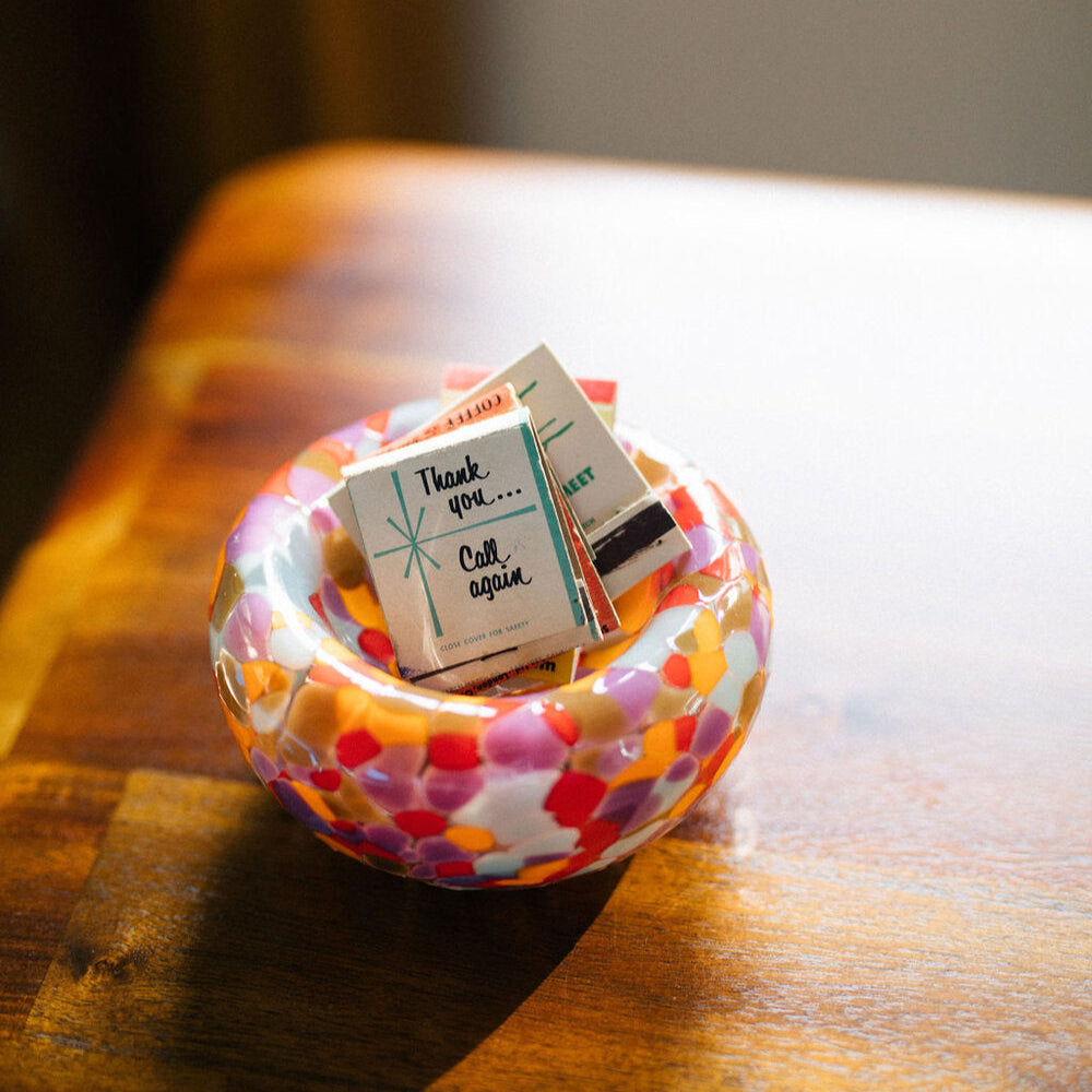 Colorful polka dot glass bowl on a wooden surface