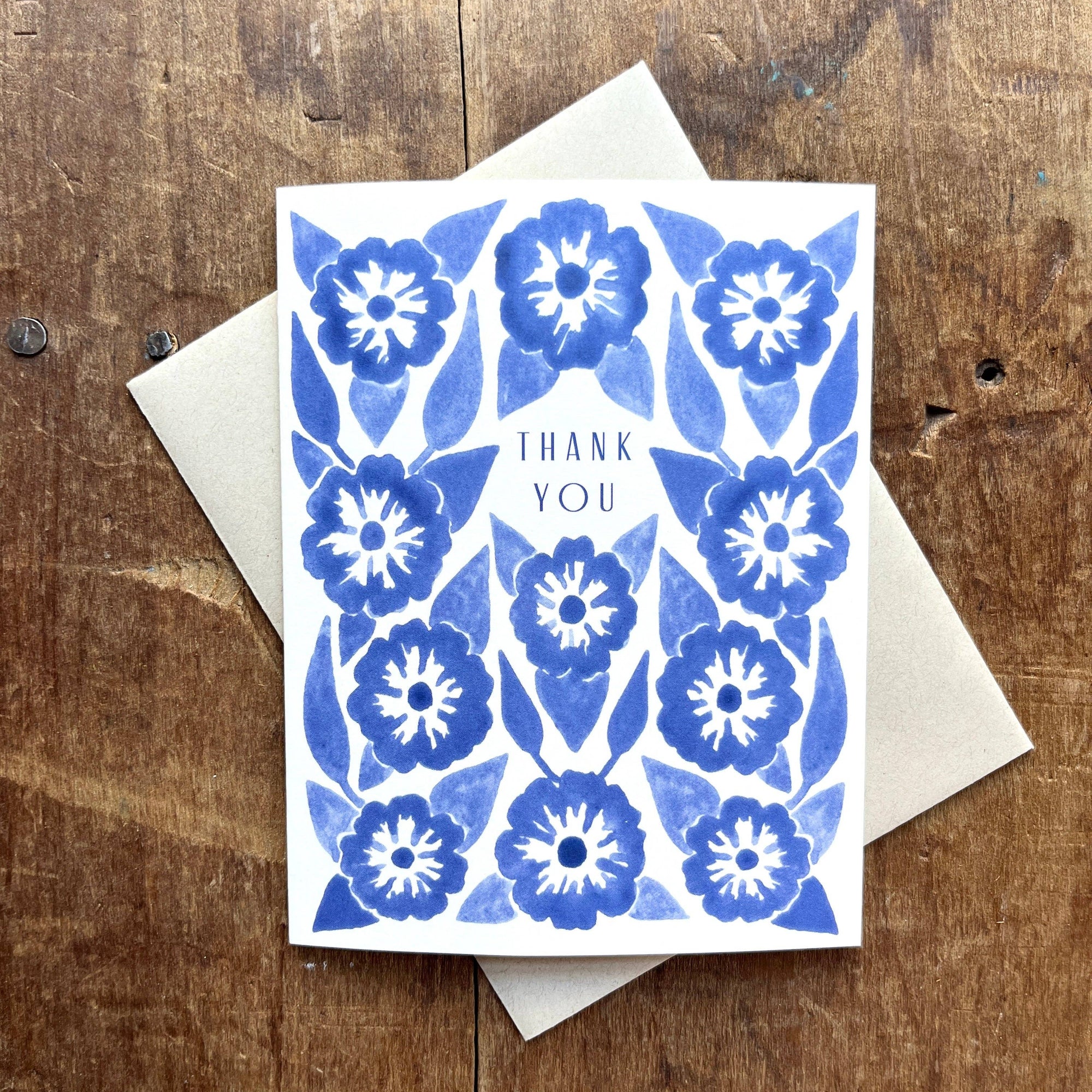 Card with blue floral pattern and 'Thank you' text on a wooden surface