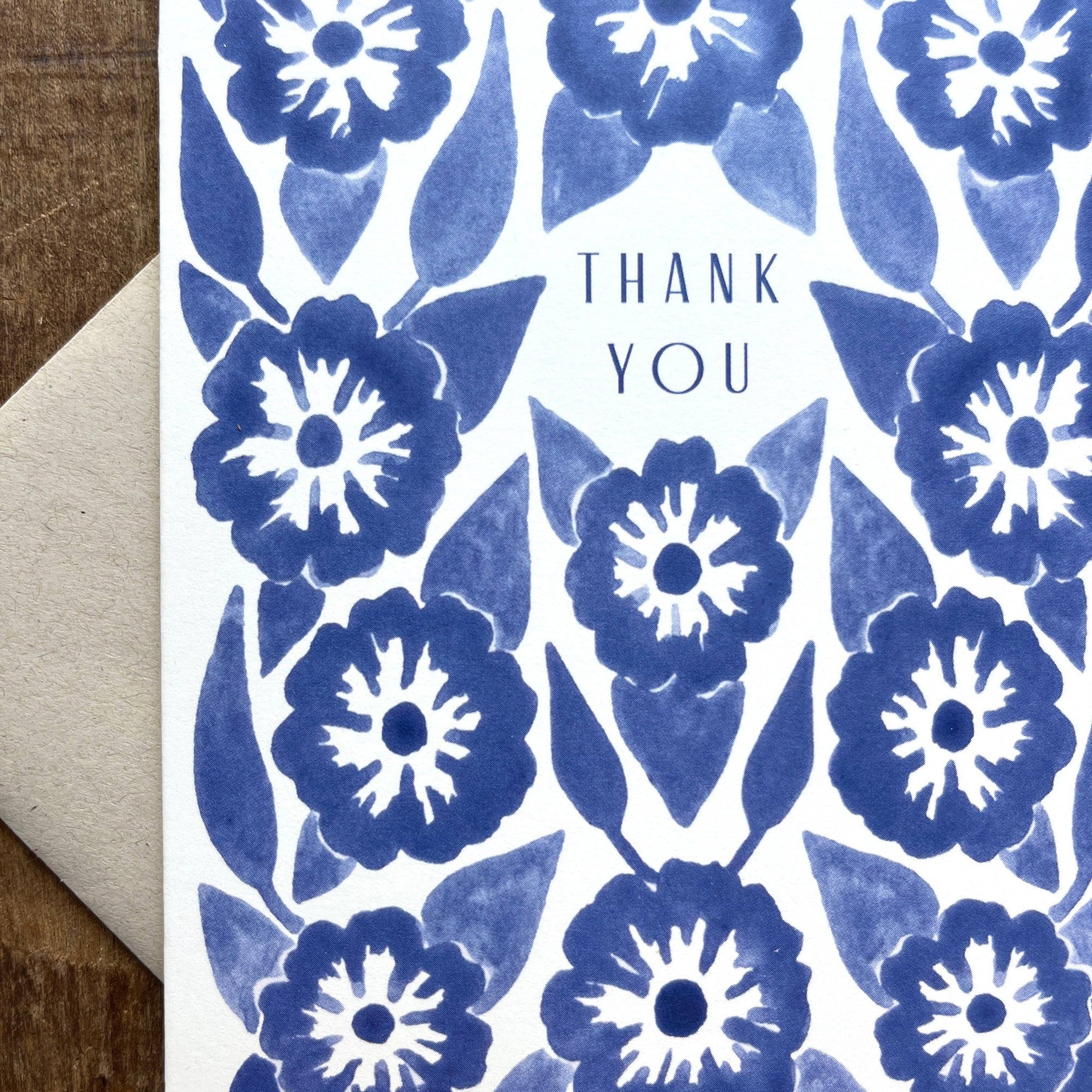 Card with blue floral pattern and 'Thank You' text on a wooden surface