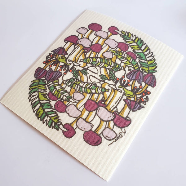 Reusable dishcloth with a colorful design of mushrooms and leaves on a white background