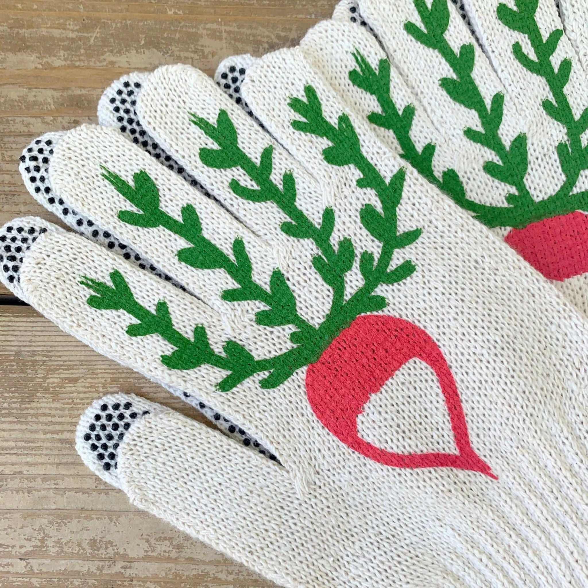 Pair of white gardening gloves with green leaf and red radish design on a wooden surface
