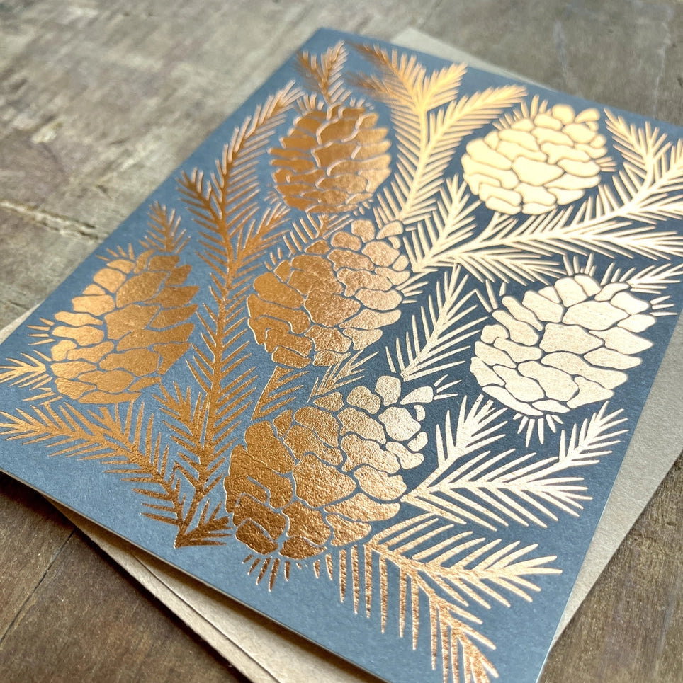 Greeting card with gold and white floral design on a blue background