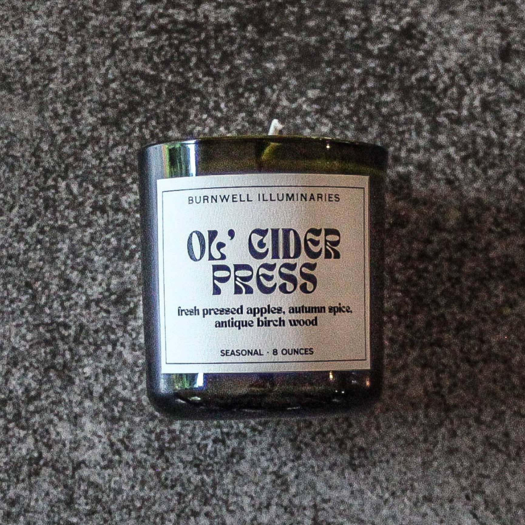 Candle with a label on a textured surface