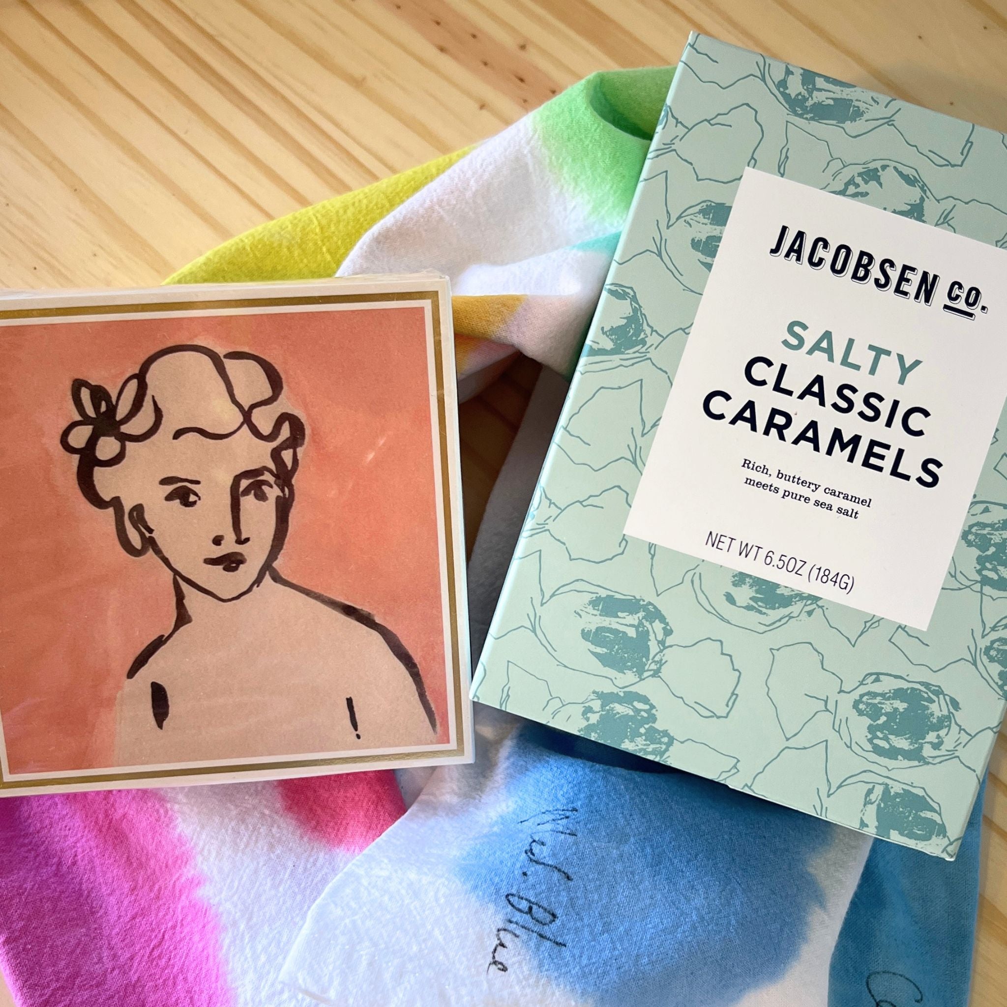 Box of Jacobsen Salty Classic Caramels with a card featuring a stylized illustration on a colorful fabric background.