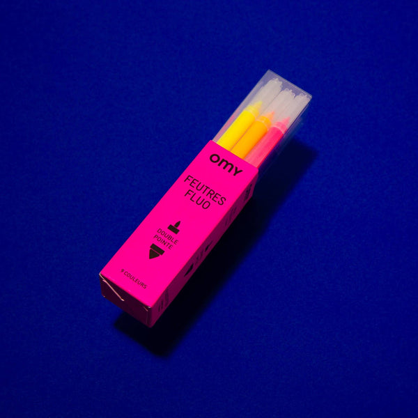 Pink packaging of fluorescent markers with yellow tips on a blue background