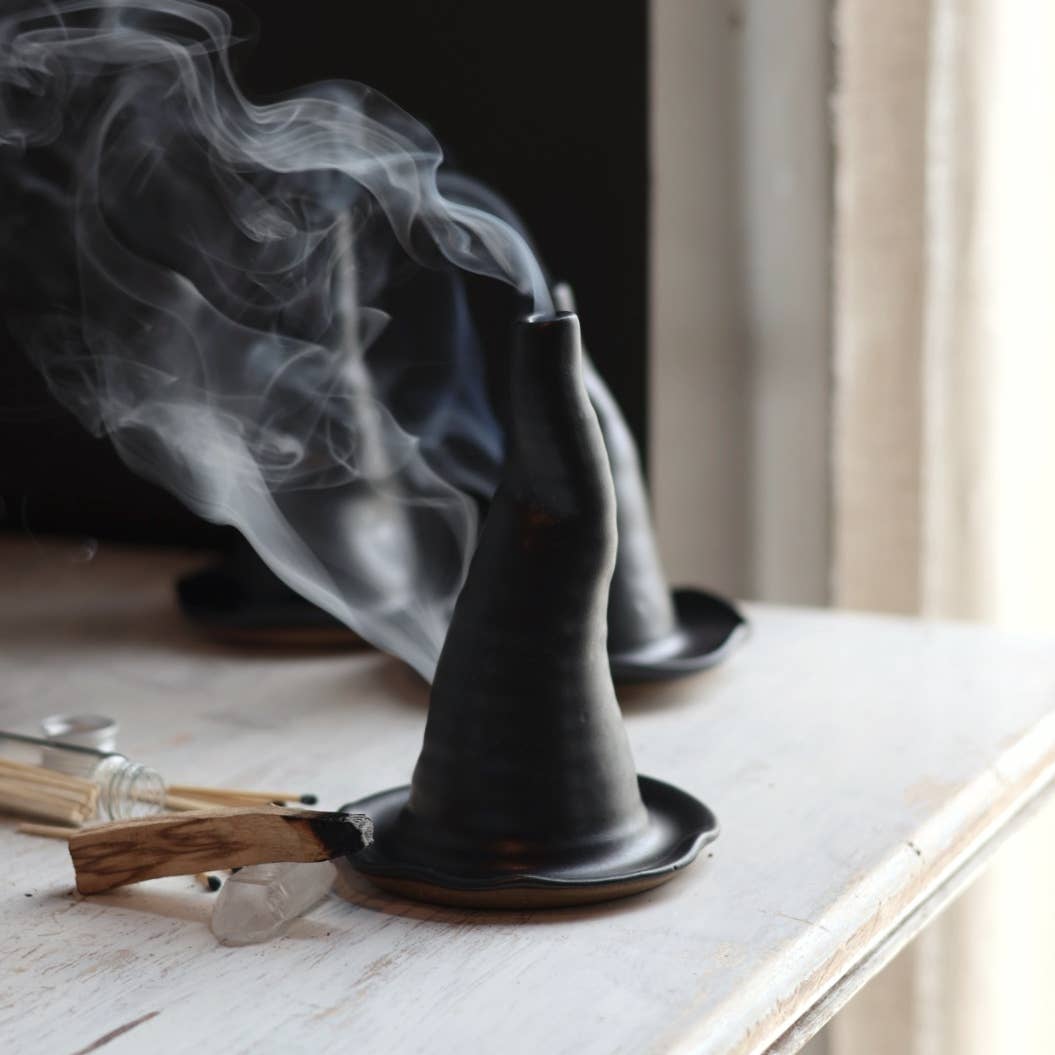 Incense cone burner with smoke on a wooden surface