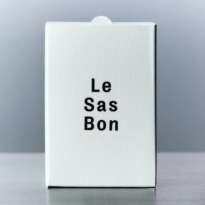 White box with 'Le Sas Bon' text on a reflective surface and gray background