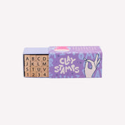 Box of containing wooden stamps for clay and a purple box on a white background
