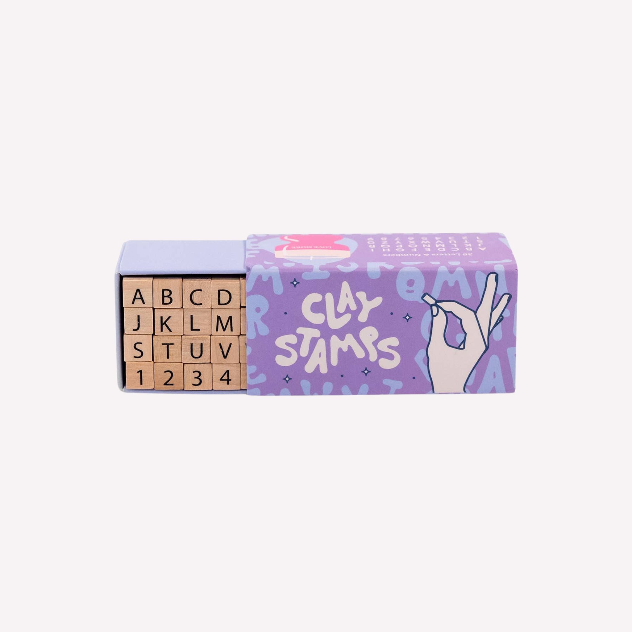Box of containing wooden stamps for clay and a purple box on a white background