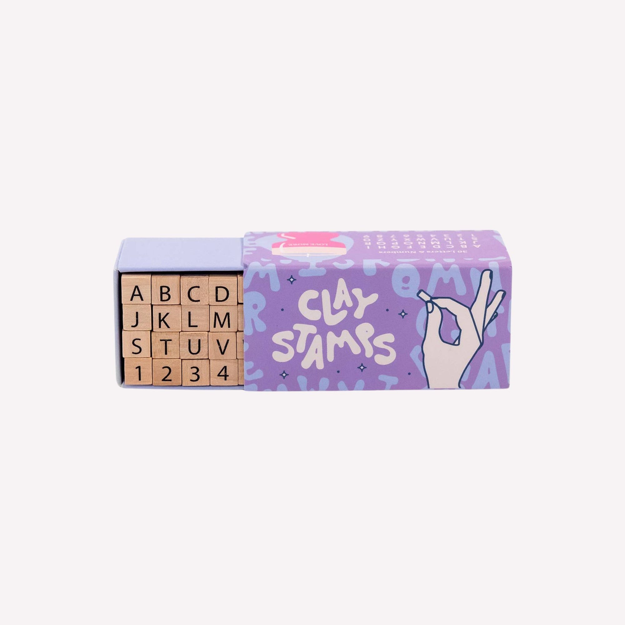 Box of containing wooden stamps for clay and a purple box on a white background