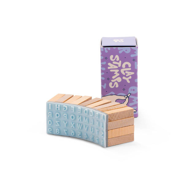 Wooden letter blocks with a purple box labeled clay stamps on a white background
