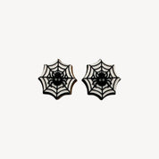 A pair of gothic spiderweb stud earrings with black spiders in the center, set against a white background with black web patterns.