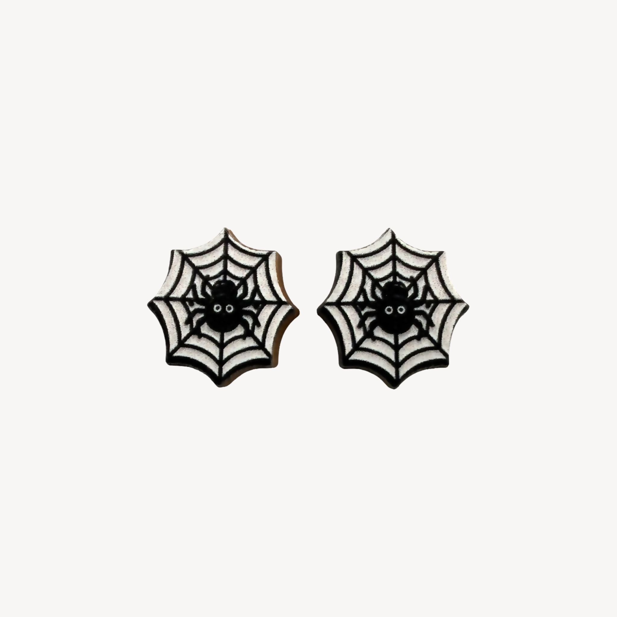 A pair of gothic spiderweb stud earrings with black spiders in the center, set against a white background with black web patterns.
