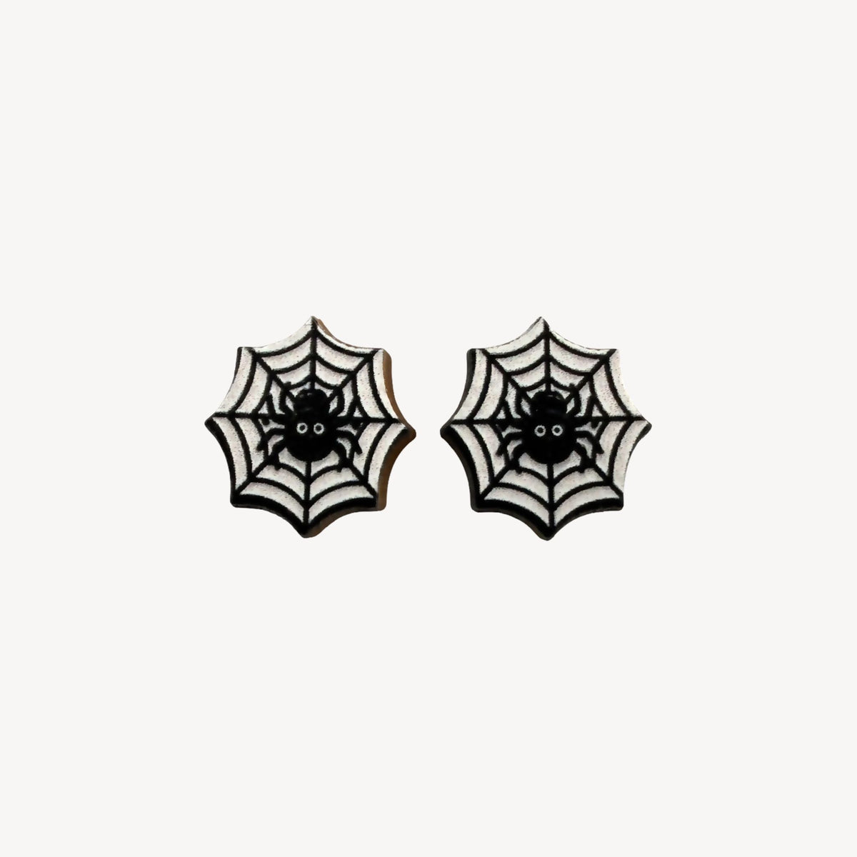 A pair of gothic spiderweb stud earrings with black spiders in the center, set against a white background with black web patterns.