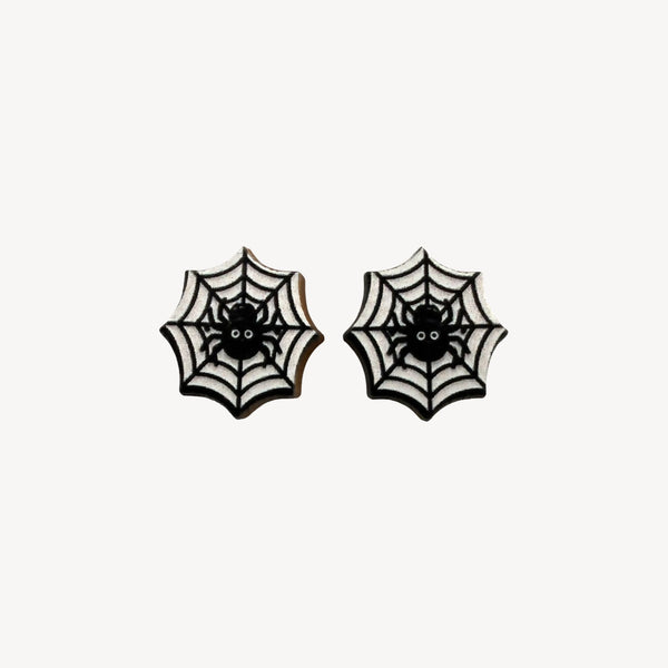 A pair of gothic spiderweb stud earrings with black spiders in the center, set against a white background with black web patterns.