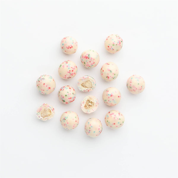Decorative beads with gold and pink speckles on a white background