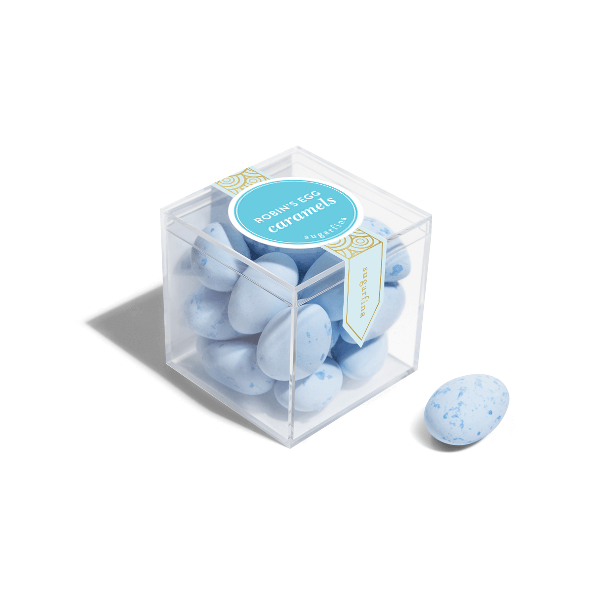 Clear cube container with blue caramels and a label on a white background
