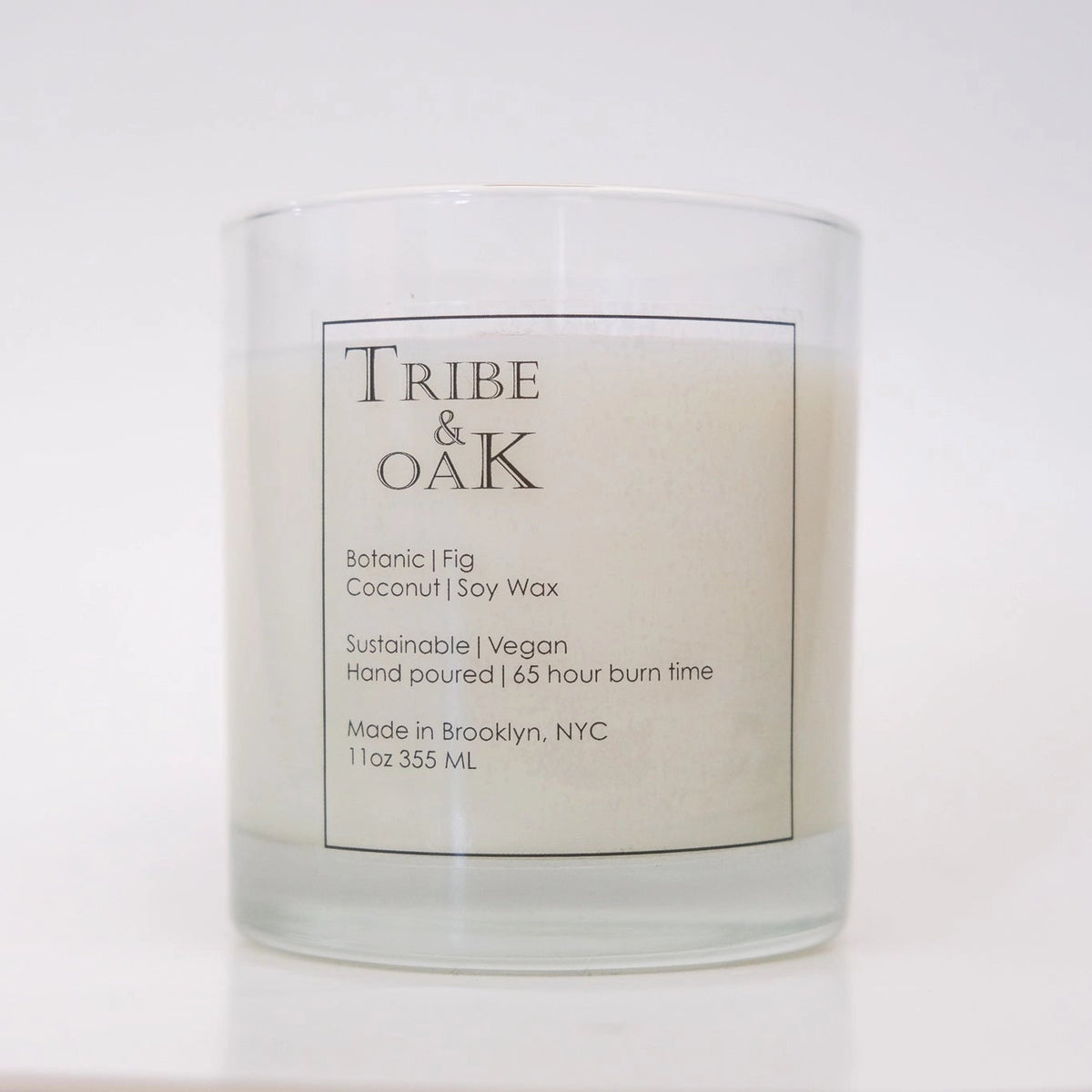 Candle with 'Tribe & Oak' label on a white background
